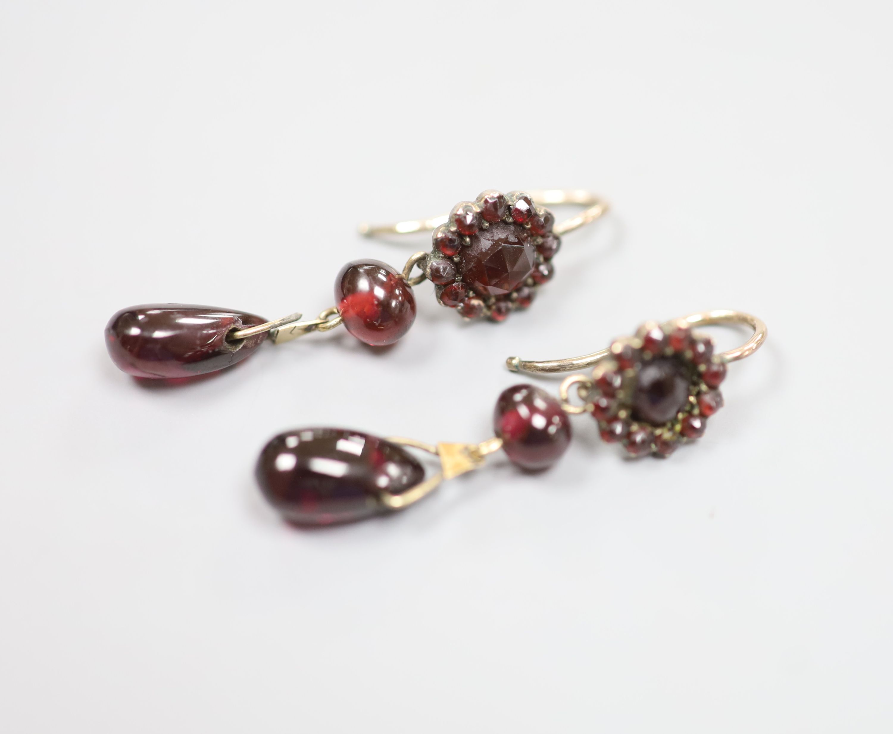 A pair of late Victorian gilt white metal?, facet, bead and pear shaped garnet set drop earrings